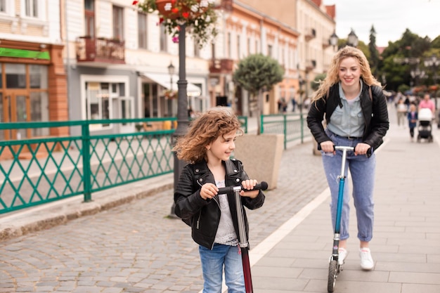 La ragazza guida per la prima volta uno scooter insieme alla mamma