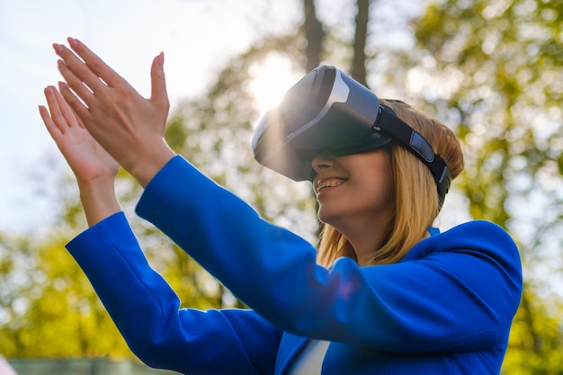 La ragazza ha allungato le mani verso il cielo con gli occhiali della realtà virtuale