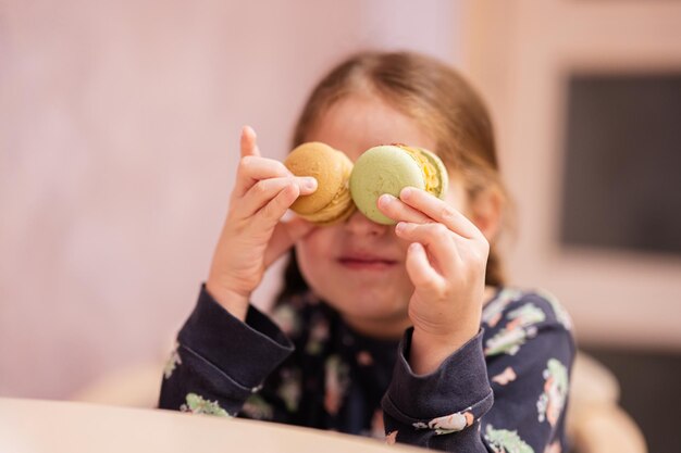 La ragazza ha messo gli occhi deliziosi gustosi macaron di colore dolce