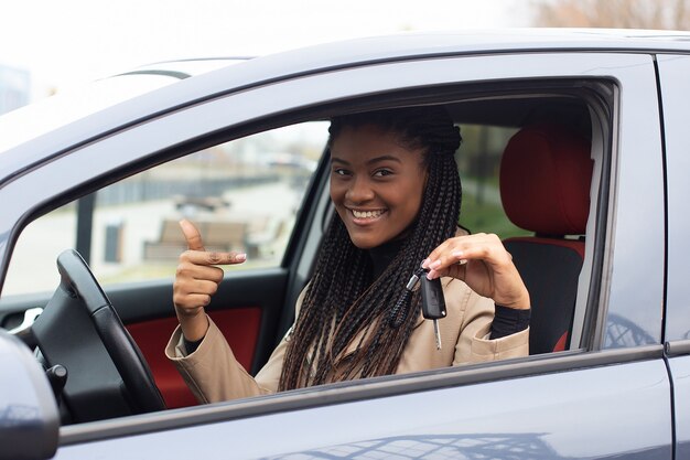 La ragazza Happy ha noleggiato un'auto, afroamericana