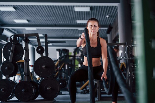 La ragazza in abiti sportivi è in palestra durante il giorno.