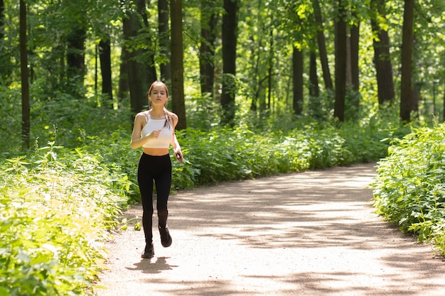 La ragazza in cuffia va a correre nel parco