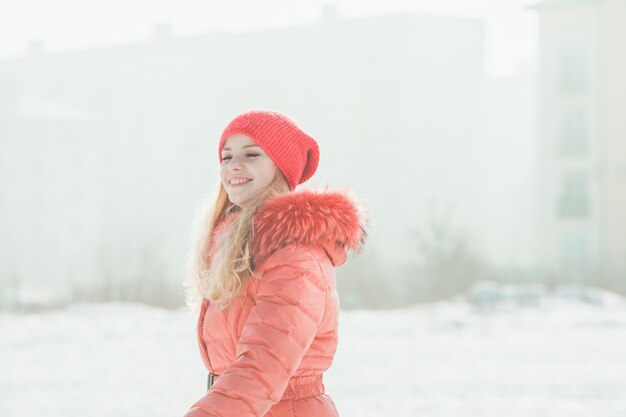 La ragazza in parka rosso sta camminando in una giornata invernale. Ritratto invernale di donna