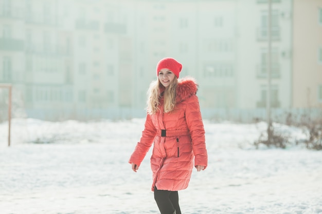 La ragazza in parka rosso sta camminando in una giornata invernale. Ritratto invernale di donna