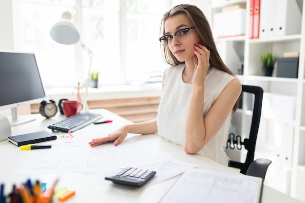 La ragazza in ufficio si siede al tavolo