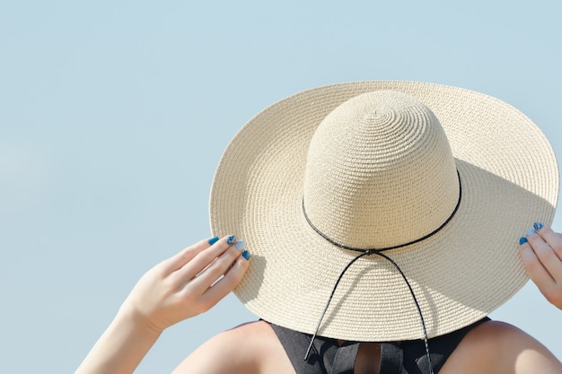 La ragazza in un cappello guarda il cielo.