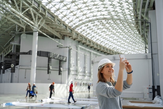 La ragazza in un casco con un telefono scatta foto