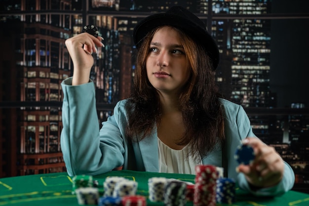 La ragazza in un casinò gioca a poker con la sicurezza di vincere il gioco poker donna con le carte