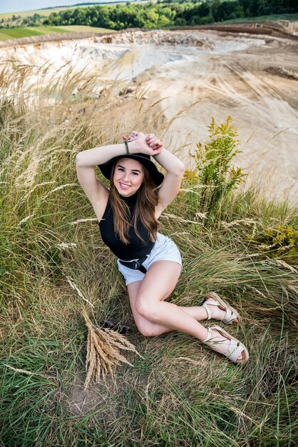 La ragazza in un panno casual in un campo verde rurale va in estate. stile di vita