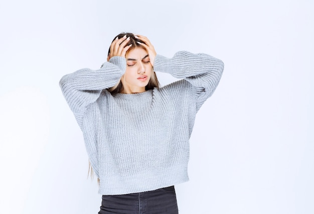 La ragazza in una camicia grigia sembra terrorizzata e spaventata.