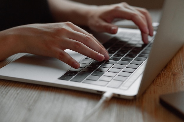 La ragazza lavora a casa per un laptop La mano sul touchpad fa clic sulle informazioni