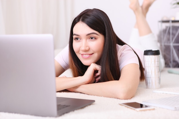 La ragazza lavora al laptop a casa