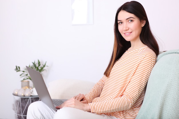 La ragazza lavora al laptop a casa