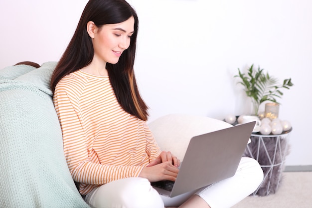 La ragazza lavora al laptop a casa