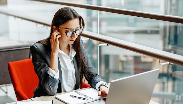 La ragazza lavora su un laptop sul posto di lavoro