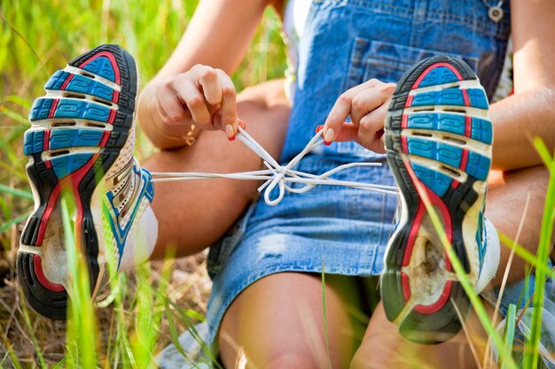 La ragazza lega i lacci delle scarpe da ginnastica al ragazzo