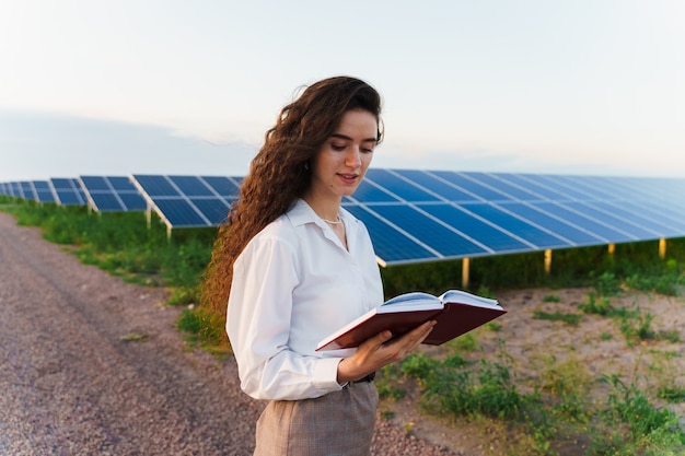 La ragazza legge vicino alle righe del pannello solare sul terreno