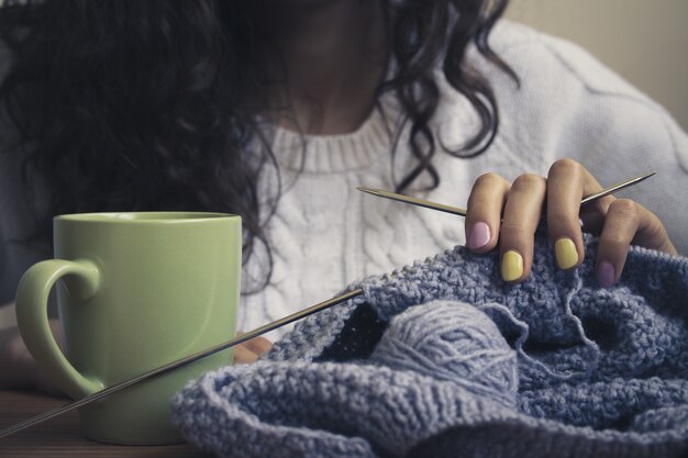 La ragazza, maglieria e tazza verde