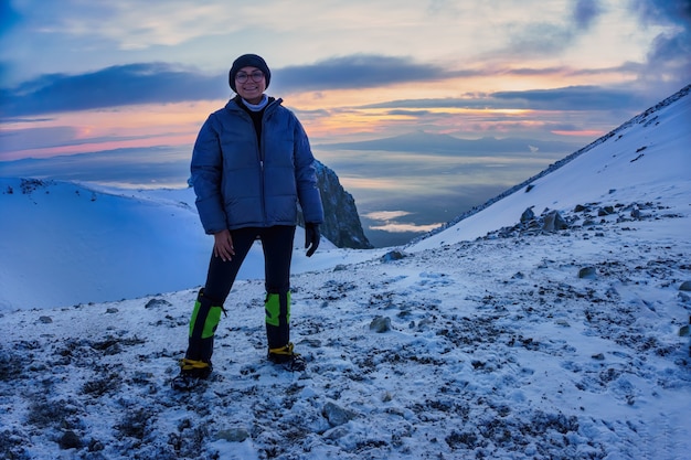 La ragazza magra è in piedi in cima alla montagna