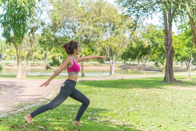 La ragazza magra gioca a yoga sul prato del parco rilassati in nutureAsian Girls ama la salute praticando lo yoga