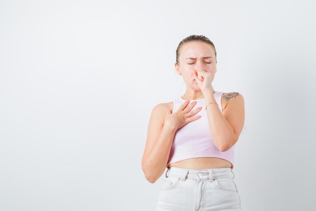 La ragazza malata sta tossendo su sfondo bianco