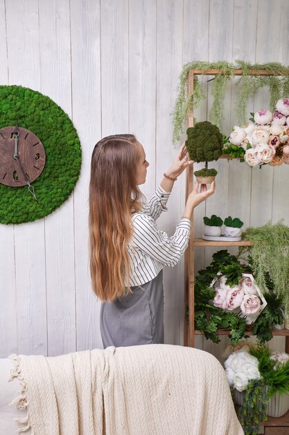 La ragazza mette i fiori sullo scaffale