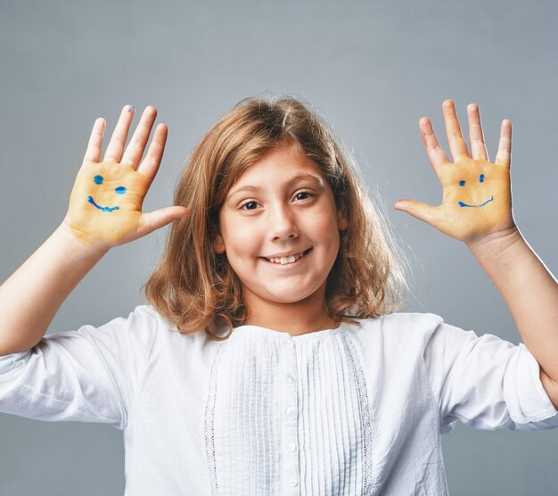 La ragazza mostra le mani con emoticon disegnate