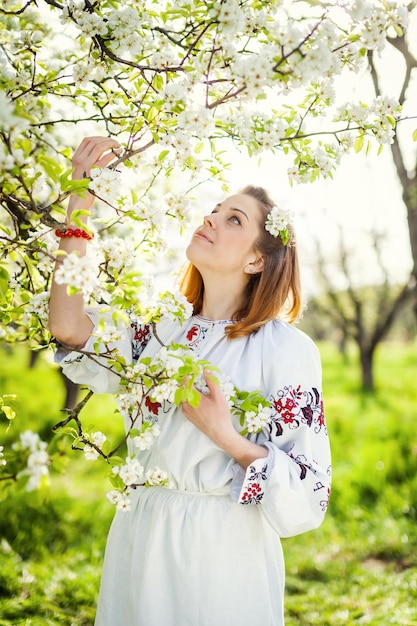 La ragazza nel giardino fiorito Mattina di primavera in un bellissimo giardino Ragazza ucraina