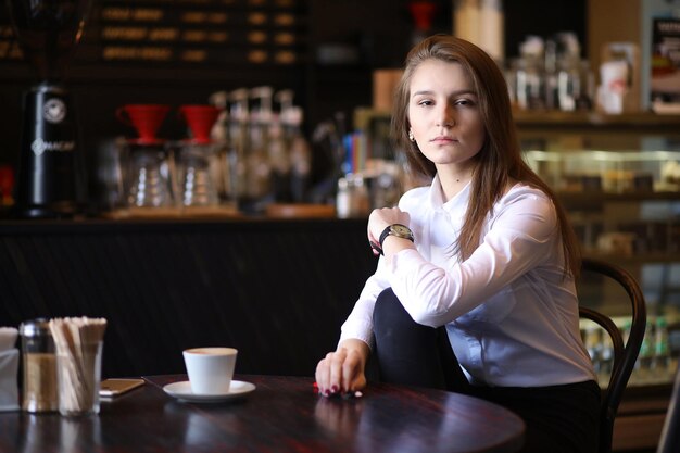 La ragazza nella colazione del caffè