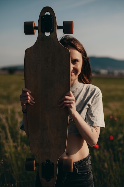 La ragazza ordinaria della ragazza di strada tiene il pattino nelle mani ritratto di una foto di alta qualità di una ragazza normale