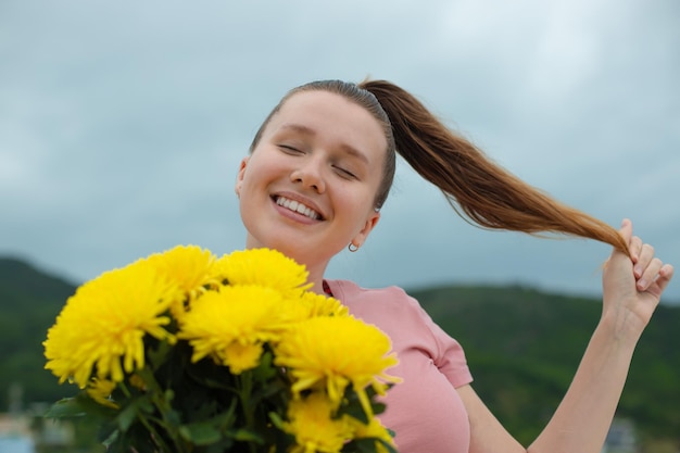 La ragazza ottiene l'occasione di anniversario del mazzo del fiore della fioritura che visita la luna di miele di viaggio all'aperto la giovane donna dà