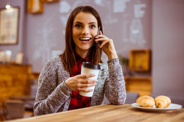 La ragazza parla al telefono e mangia.