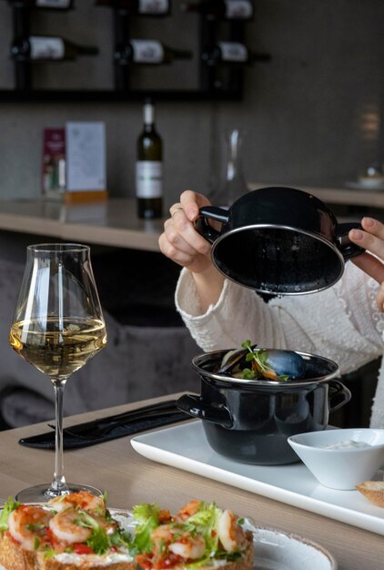 La ragazza pranza cena in un ristorante Una ragazza beve vino bianco a cena Pasto con vino