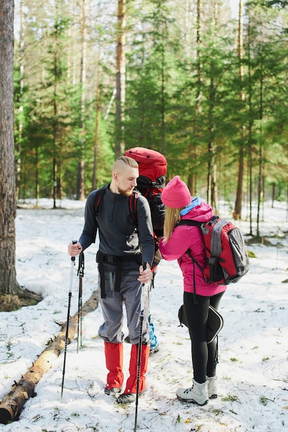 La ragazza raddrizza il turista turistico il suo zaino nella foresta di primavera