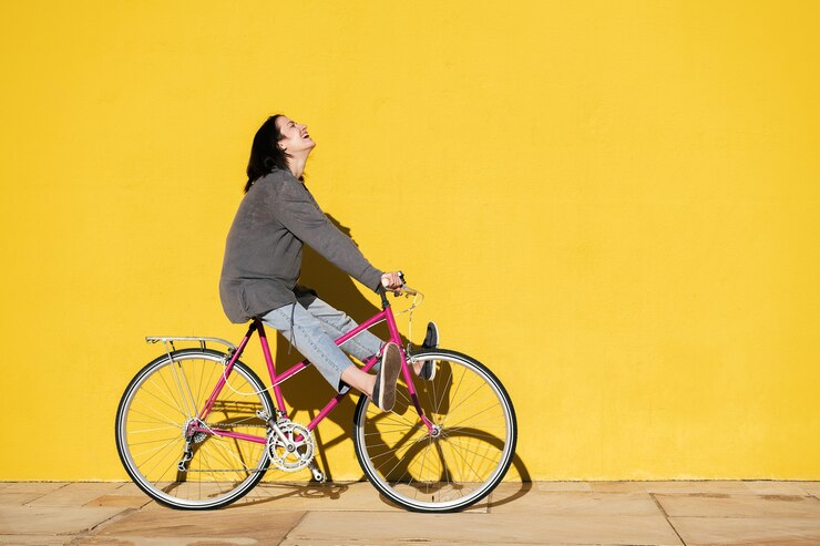 La ragazza ride mentre gioca sulla sua bici retrò