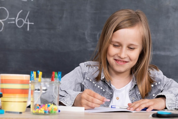 La ragazza risolve il compito dato in classe La scolaressa scrive diligentemente in un quaderno