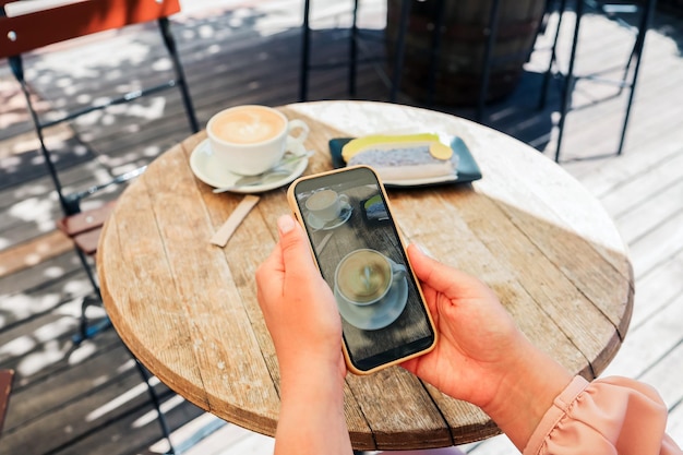 La ragazza scatta una foto del cibo in un bar