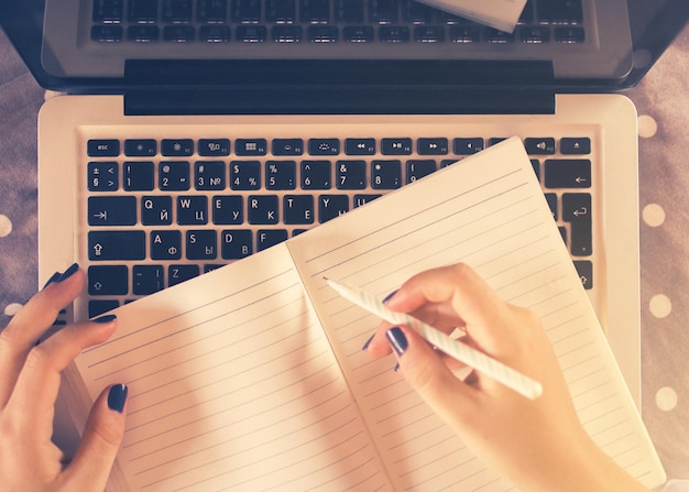 La ragazza scrive in un taccuino sul letto