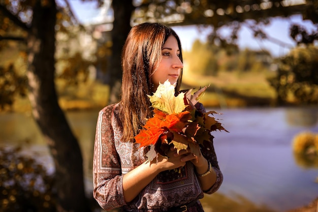 La ragazza si chiuda nel fogliame autunnale