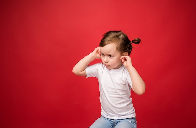 La ragazza si coprì le orecchie con le dita