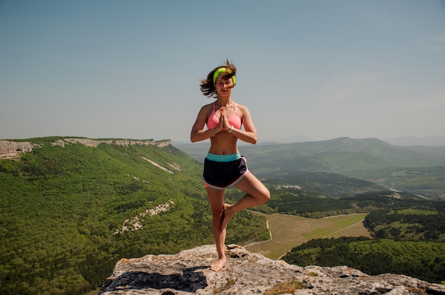 La ragazza si impegna nello yoga sulla cima della montagna. stile di vita sano.