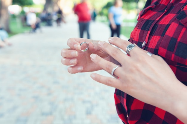 La ragazza si mette un anello nel parco