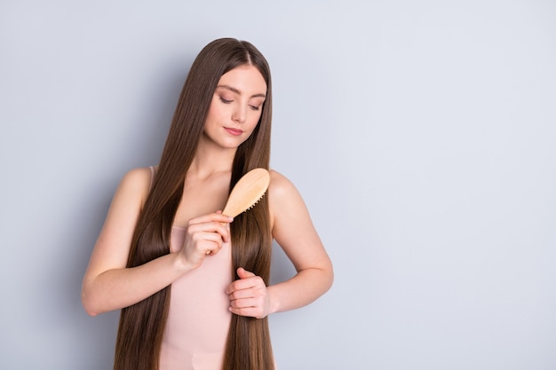 la ragazza si pettina i capelli con la spazzola per capelli