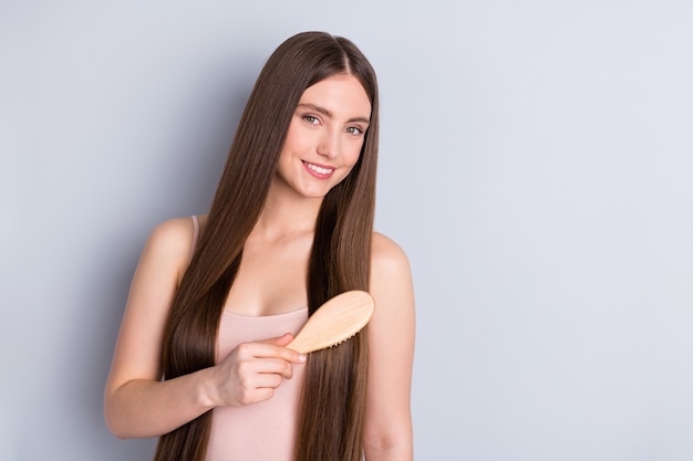 la ragazza si pettina i capelli con la spazzola per capelli