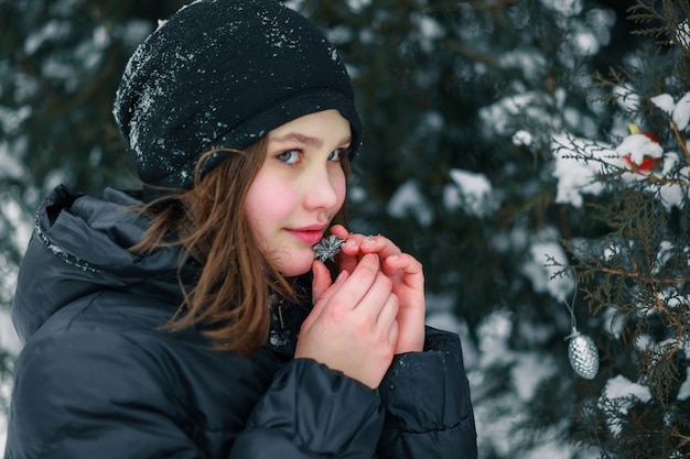 La ragazza si premette sul viso un piccolo giocattolo dell'albero di Natale. Il bambino è contento del regalo.