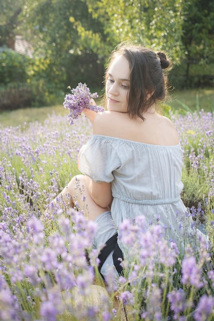 La ragazza si siede in mezzo a un campo di lavanda