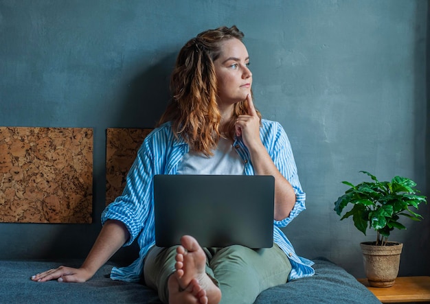 la ragazza si siede sul letto al computer freelance lavoro a casa concetto di dipendente remoto stile di vita però