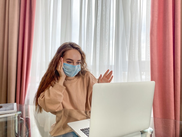 La ragazza si soffia il naso usando un tovagliolo di carta. La ragazza è seduta a casa per cure ambulatoriali. Prevenzione dell'isolamento del coronavirus