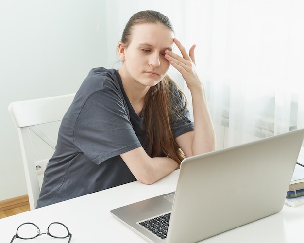 La ragazza si strofina gli occhi, gli occhi sono stanchi per la tensione e il dolore.