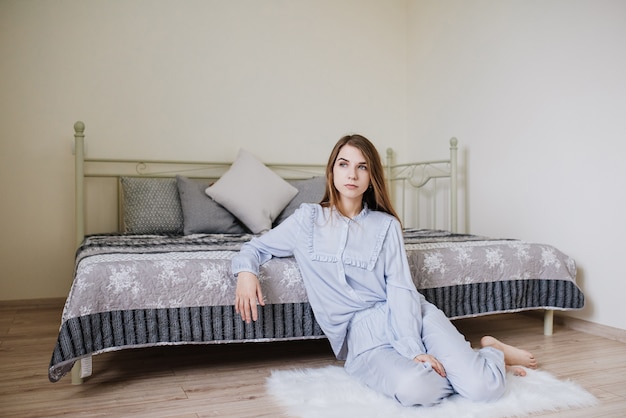 La ragazza si svegliò e si mise in pigiama sul letto nella sua stanza. Elegante interno grigio-bianco.